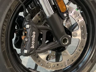 Kaliper rem Brembo hitam terpasang radial pada cakram floating roda depan dengan ban Michelin