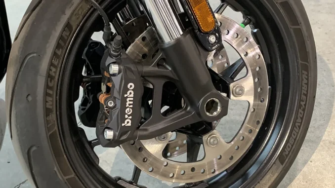Kaliper rem Brembo hitam terpasang radial pada cakram floating roda depan dengan ban Michelin