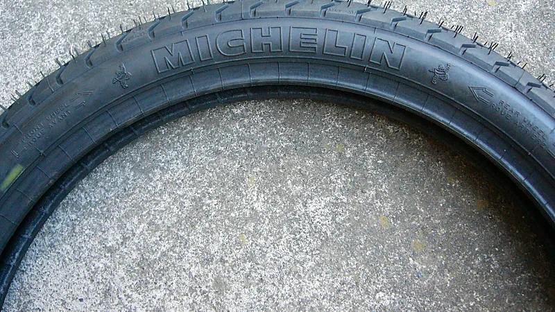 Dinding ban Michelin baru dengan tulisan timbul merek, panah rotasi, dan penanda front wheel serta rear wheel