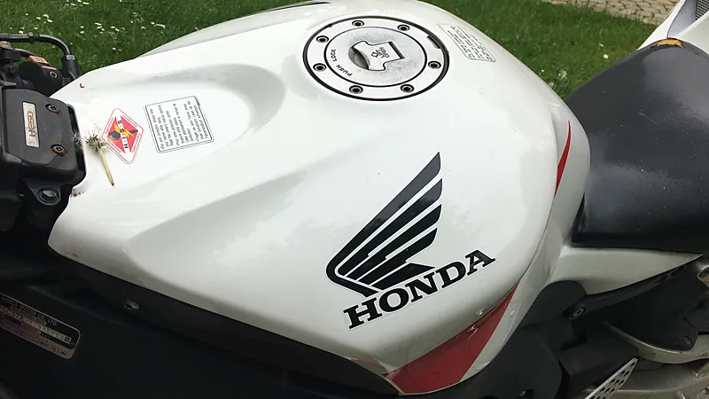 Tangki bahan bakar motor sport Honda CBR1000RR berwarna putih dengan tutup tangki berkunci di tengahnya