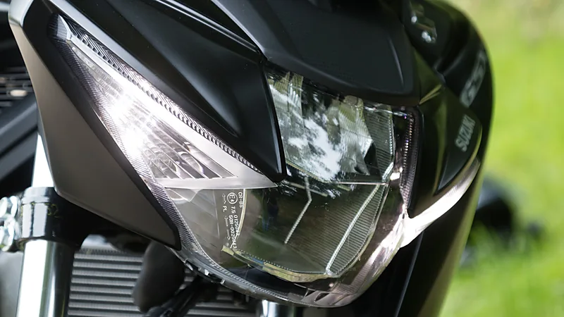 Lampu depan LED Suzuki GSX-S125 difoto dari dekat, memperlihatkan reflektor dan garis cahaya khas lampu proyektor