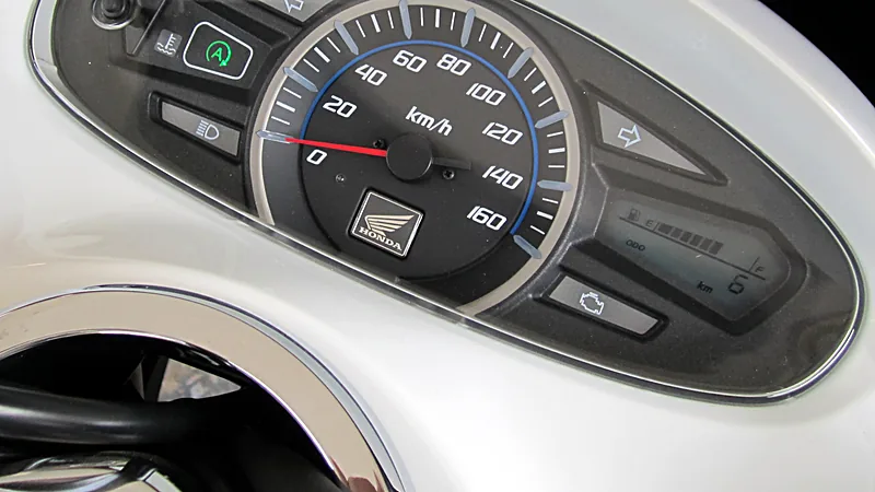 Speedometer Honda PCX150 dengan ikon lampu check engine berbentuk blok mesin di kanan bawah, di samping layar indikator bensin