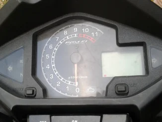 Panel meter Honda MegaPro dengan takometer bertuliskan PGM-FI Fuel Injection dan ikon lampu check engine (MIL) di bawah angka nol