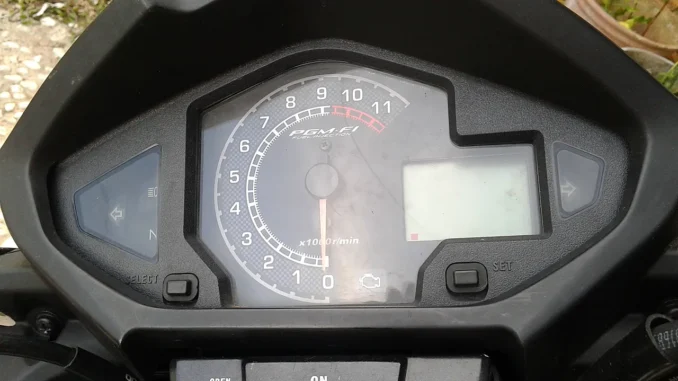 Panel meter Honda MegaPro dengan takometer bertuliskan PGM-FI Fuel Injection dan ikon lampu check engine (MIL) di bawah angka nol