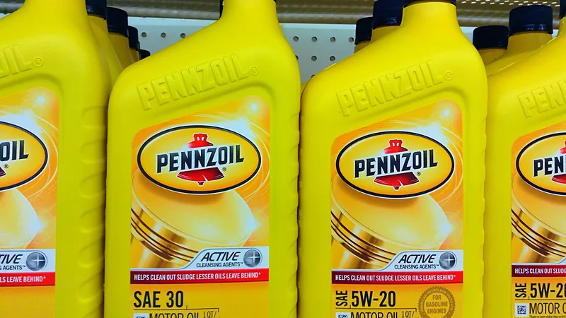 Deretan botol oli mesin Pennzoil di rak toko dengan kode kekentalan SAE 30 dan 5W-20 terbaca jelas di labelnya