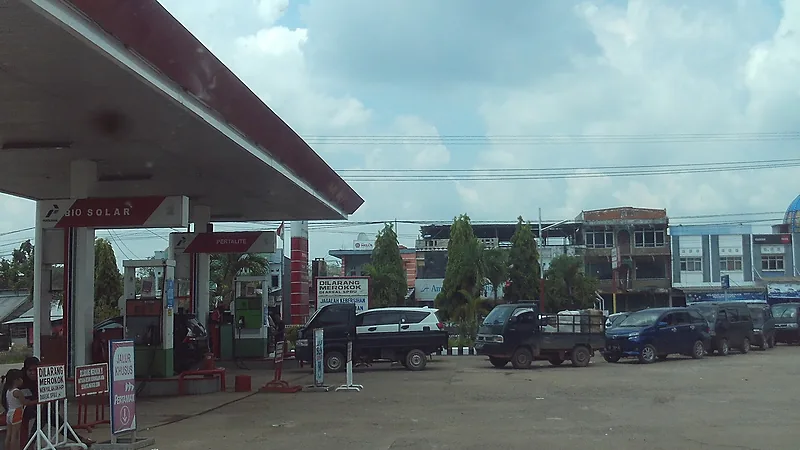 SPBU Pertamina di Indonesia dengan pompa Pertalite dan Bio Solar, mobil mengantre mengisi bahan bakar di bawah kanopi merah