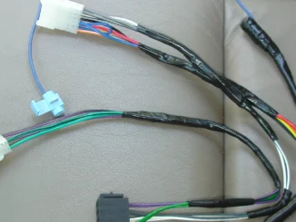 Kabel bodi kendaraan dengan selongsong soket putih dan kabel warna biru, merah, oranye, kuning, hijau, putih, ungu, dan cokelat