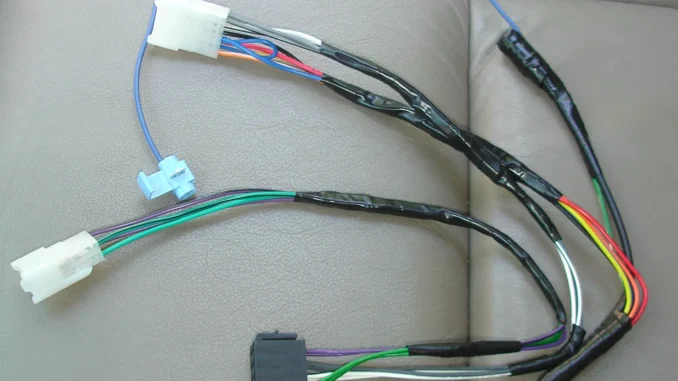Kabel bodi kendaraan dengan selongsong soket putih dan kabel warna biru, merah, oranye, kuning, hijau, putih, ungu, dan cokelat