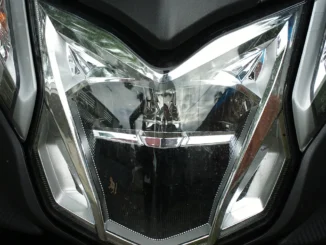Lampu depan skuter matik dalam keadaan padam dilihat dari depan