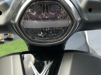 Lampu depan LED pada skuter VinFast Klara dengan garis lampu senja di tengah dan reflektor bersegmen di bawahnya